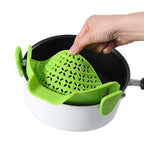 Hand clipping a green silicone strainer onto the rim of a white pot