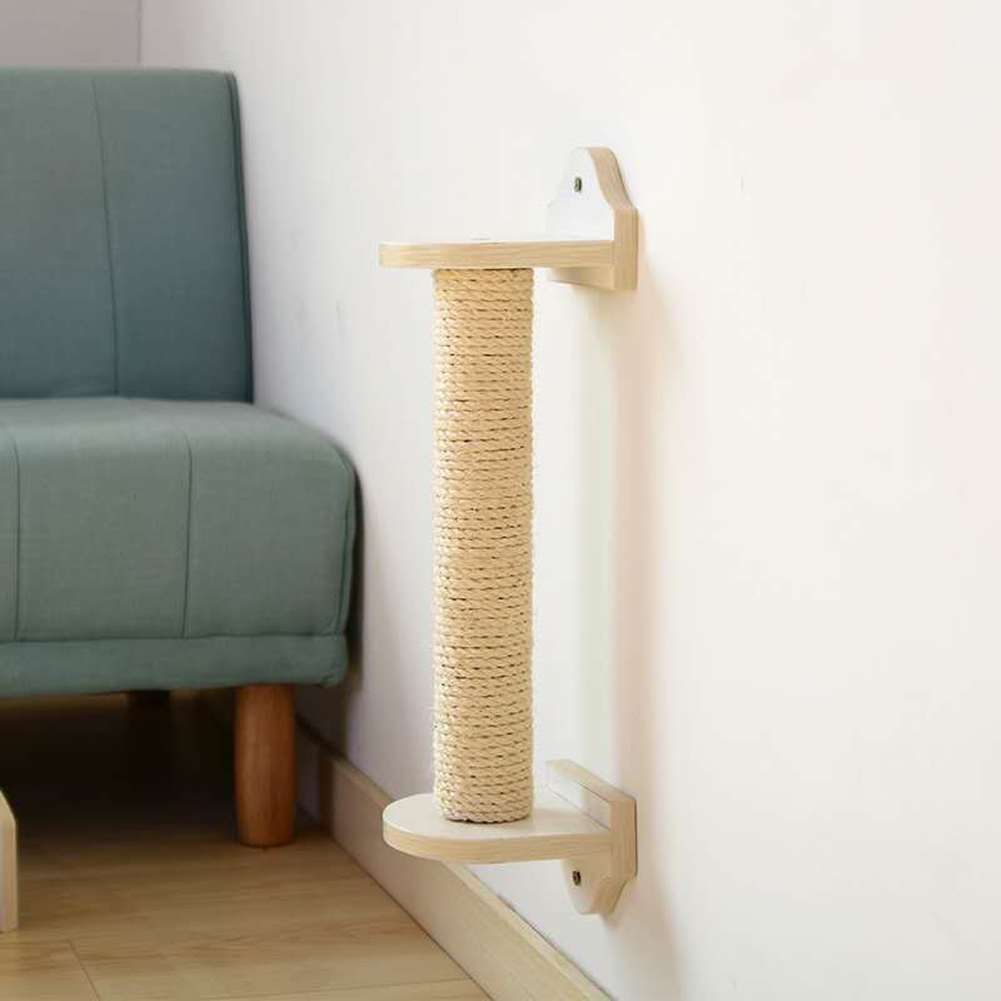 Sisal rope cat scratching post fixed to a living room wall beside a sofa