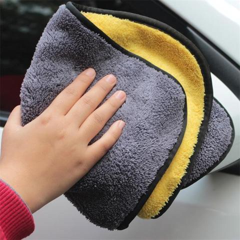 Grey and yellow microfibre towel wiping a car side mirror