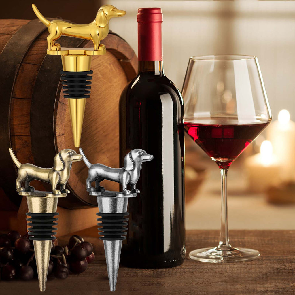 Gold, Bronze and Dark Silver dachshund wine stoppers beside a wine bottle and glass