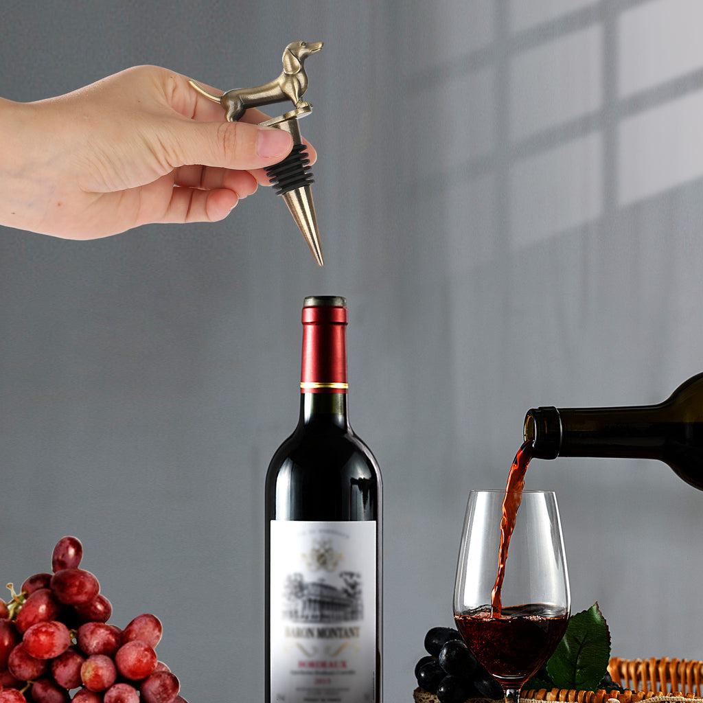 Hand placing a dachshund wine stopper into a bottle