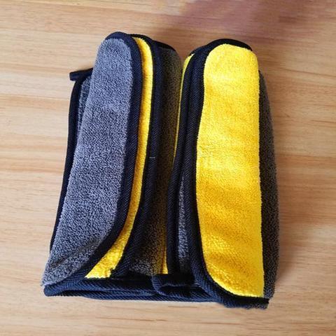 Yellow and grey cleaning towel used on a car door mirror