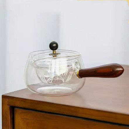 Grey glass teapot with wooden handle, white background