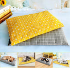 Cat lying on a stack of yellow pet bed mats