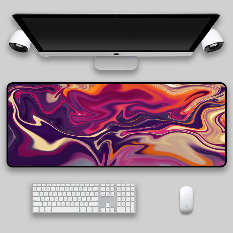 Purple, magenta and orange swirl desk mat on a desk setup