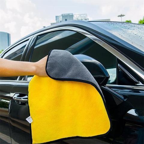 Hand wiping a car door with a yellow and grey two-tone towel