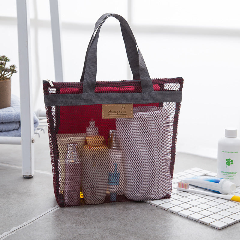 Wine red mesh tote bag holding toiletries and a towel