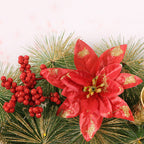 Close-up of a red glitter poinsettia and red berries on pine-needle style greenery