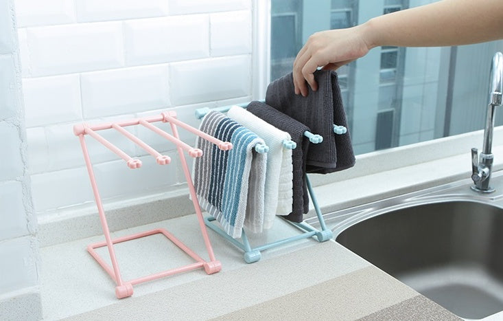Folding rack on a counter with a cup and lid drying beside it