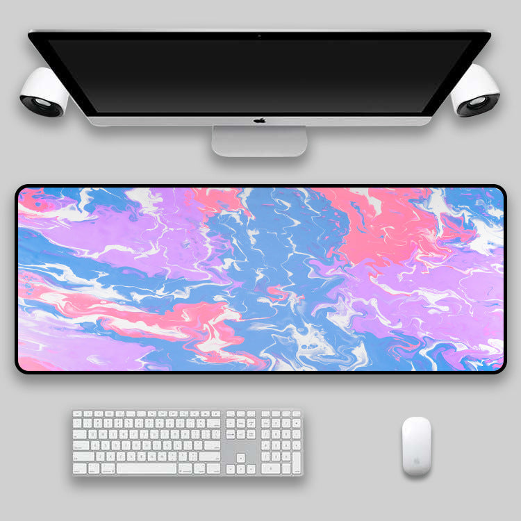 Black, white and red swirl desk mat on a desk setup
