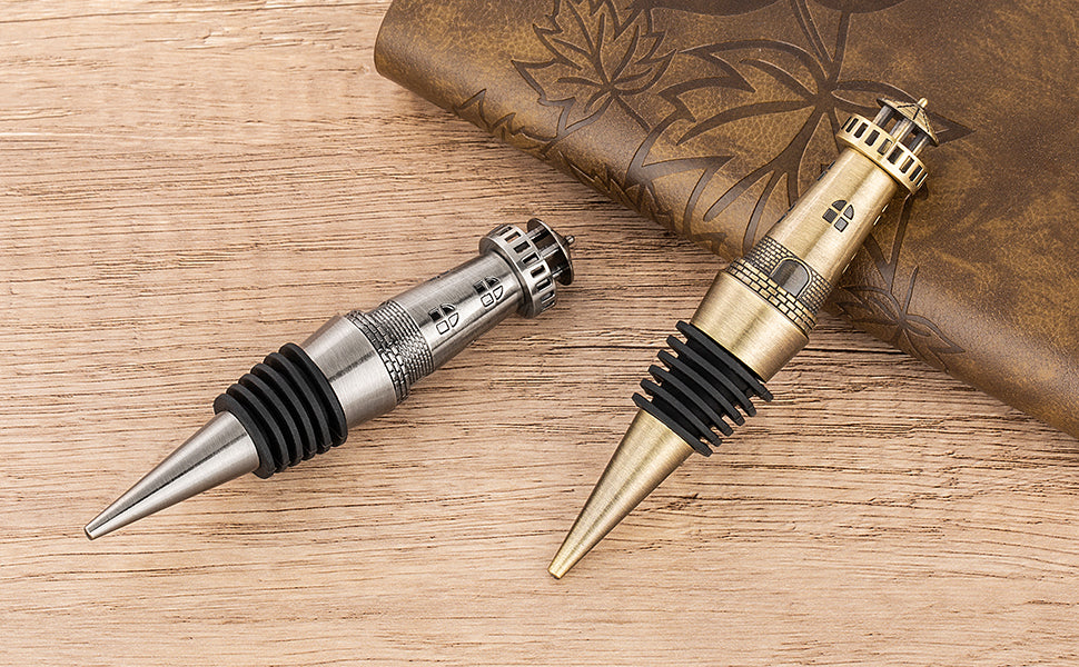 Bronze and Dark Silver lighthouse wine stoppers on a wooden table