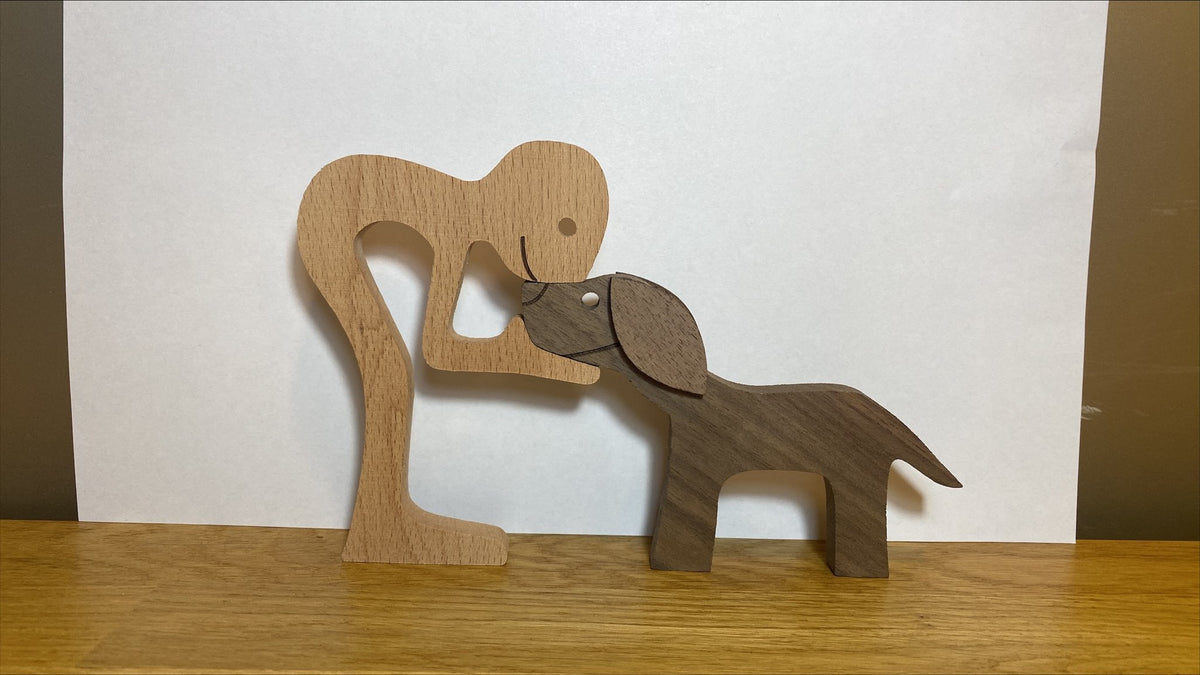 Wooden person and dog figurine, Style 8: person leaning toward a small dog on a wooden table