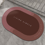 Red-brown oval bath mat with a dark brown centre on a stone floor
