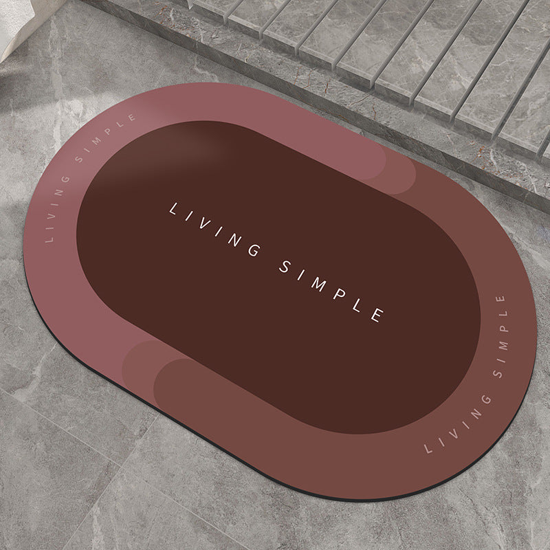 Red-brown oval bath mat with a dark brown centre on a stone floor