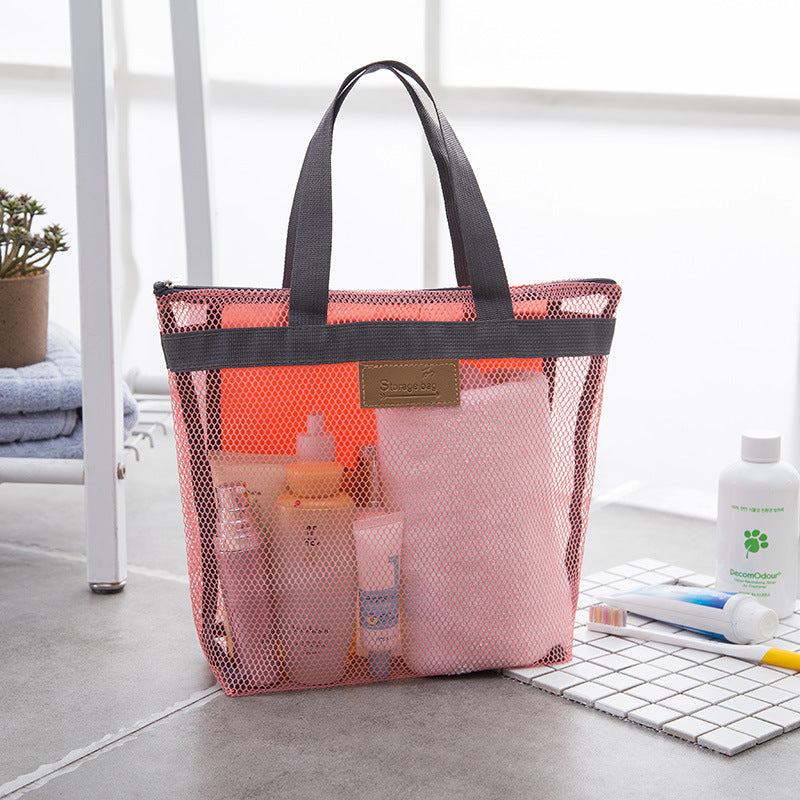 Pink mesh tote bag holding toiletries and a towel