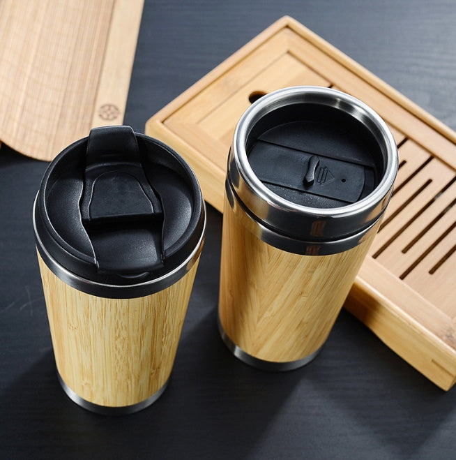 Two bamboo coffee cups, one with the flip lid open