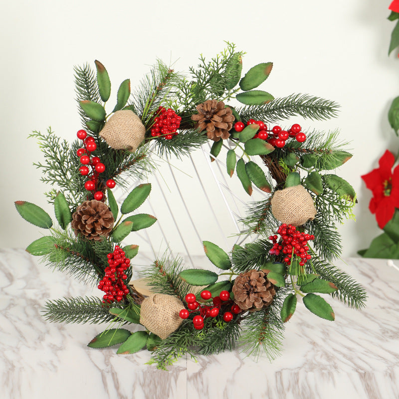 Greenery Christmas wreath with pine cones, red berries and leaves on a marble surface