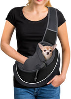 Woman wearing a black pet sling carrier with a small dog inside