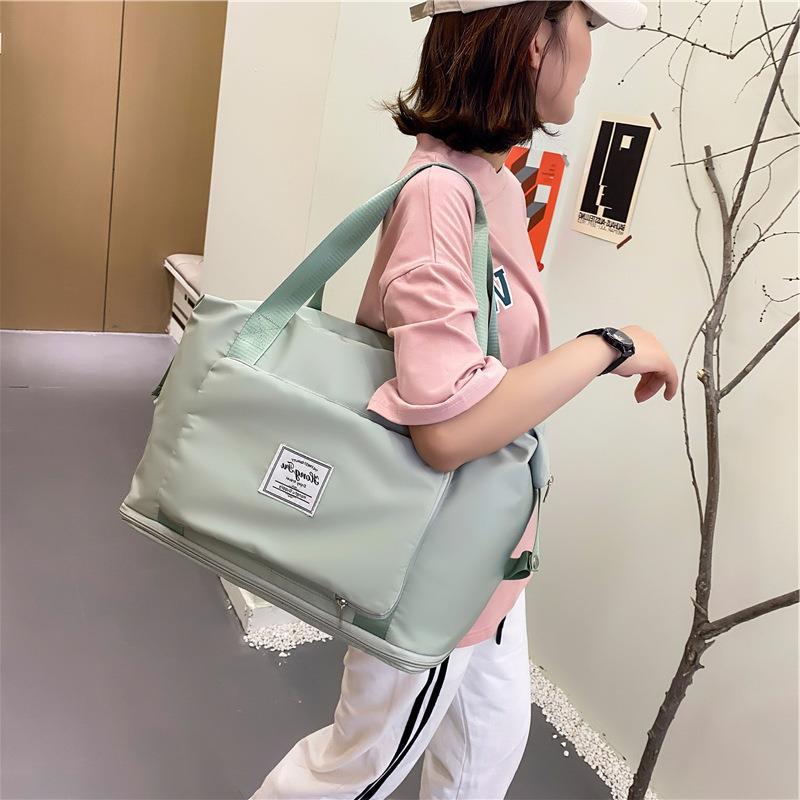 Woman carrying a green foldable duffel bag over her shoulder