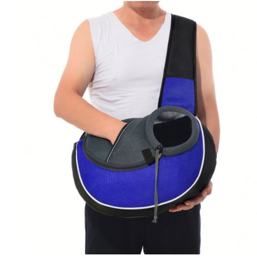 Person wearing a blue and black pet sling carrier with the opening visible