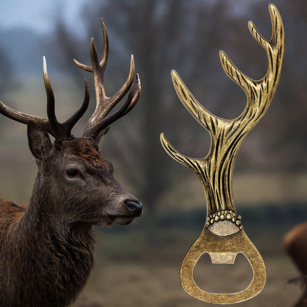 Bronze deer antler bottle opener next to a stag in the woods