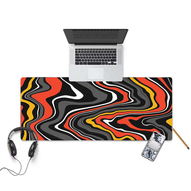 Black, white and mint swirl desk mat on a wooden desk with a laptop