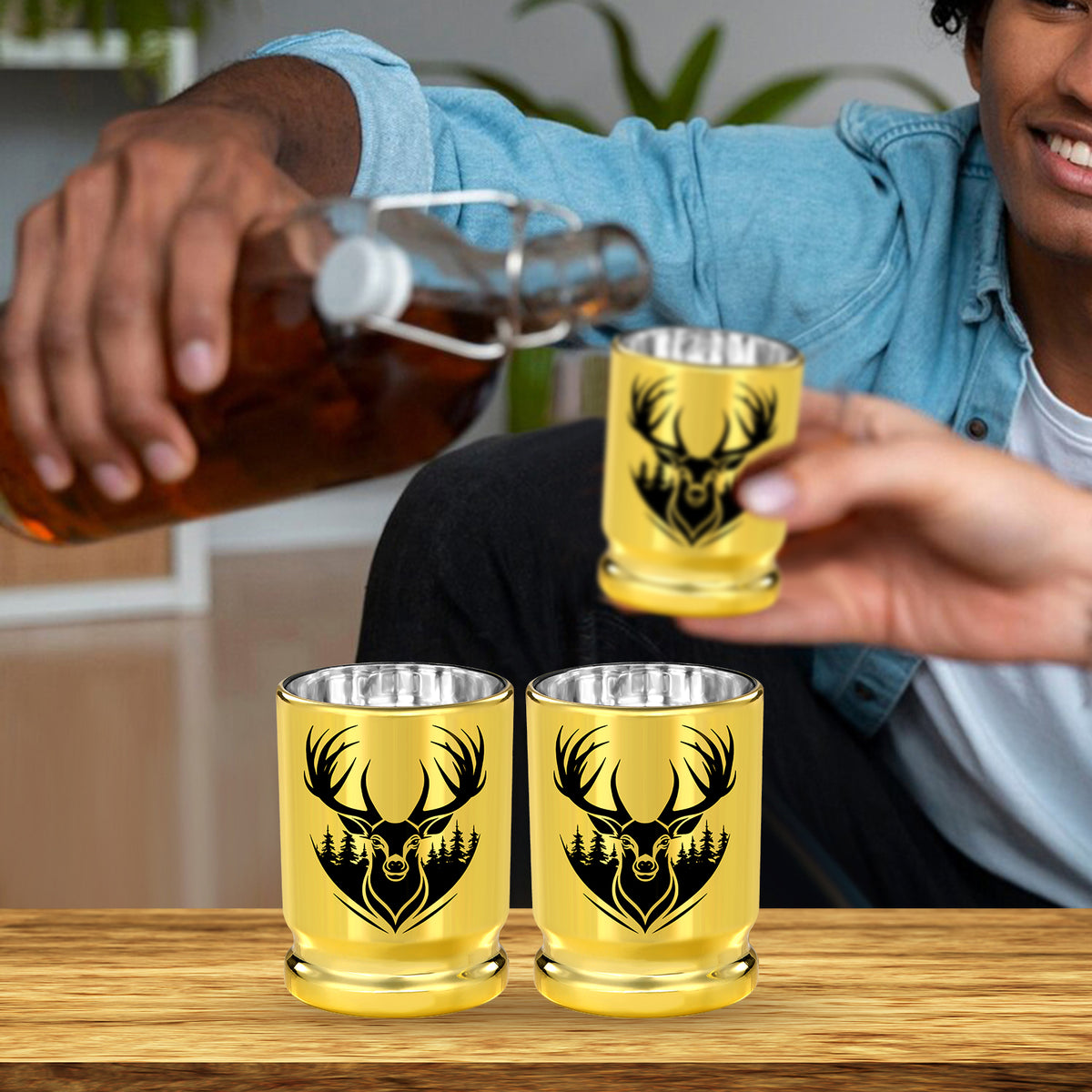 Person pouring whiskey into gold deer head shot glasses
