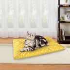 Cat resting on a yellow pet bed mat