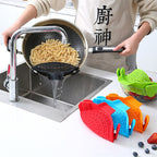 Clip-on silicone strainers in several colours beside a pot draining noodles at the sink