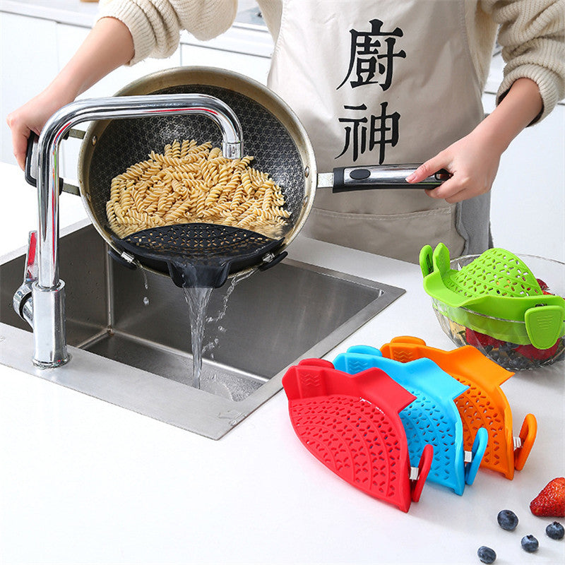 Clip-on silicone strainers in several colours beside a pot draining noodles at the sink