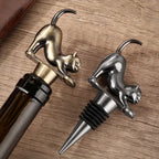 Bronze and Dark Silver stretching cat wine stoppers on a wooden table
