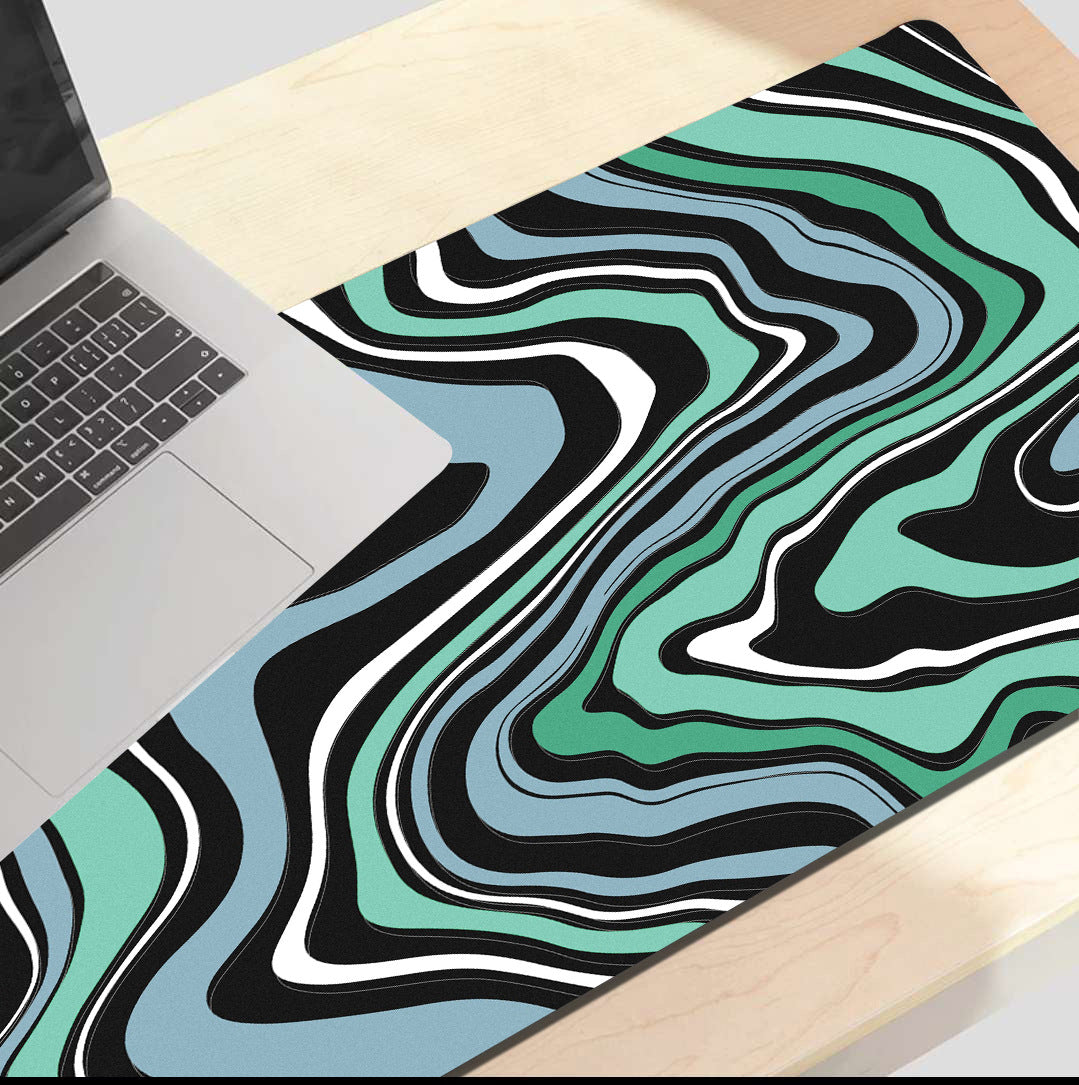 Black, red and yellow swirl desk mat on a desk setup