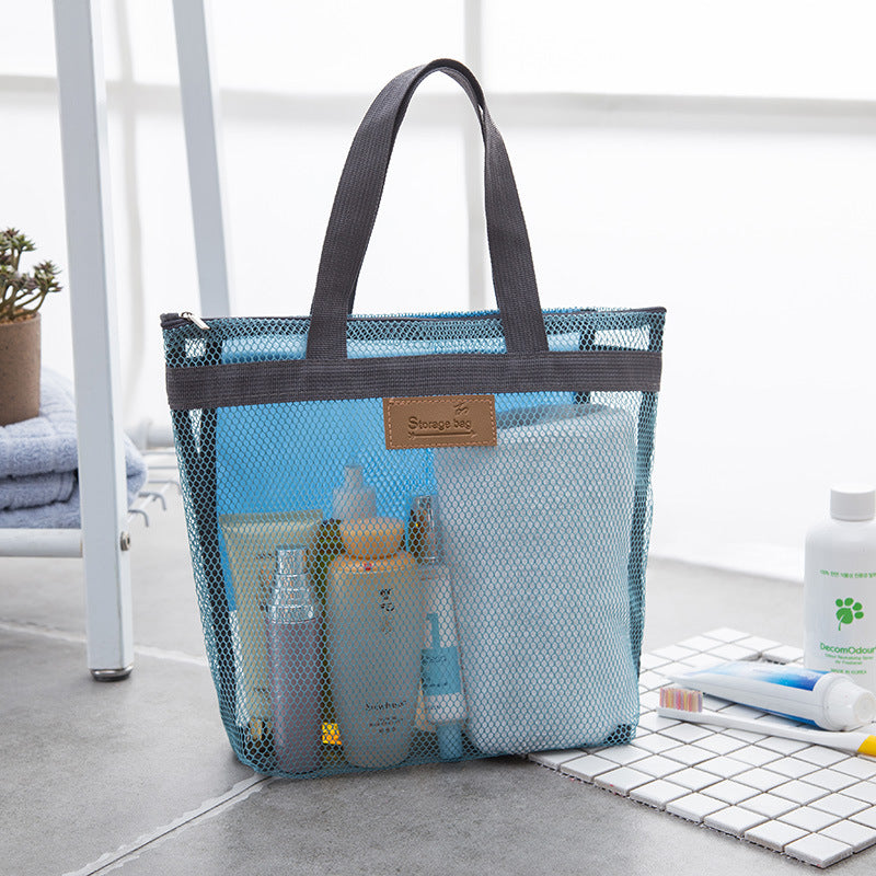 Sky blue mesh tote bag holding toiletry bottles and a towel on a bathroom shelf