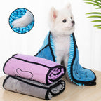 Small white dog wrapped in a blue microfiber pet towel beside rolled purple and grey towels