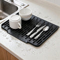 Black silicone dish drying mat on a counter