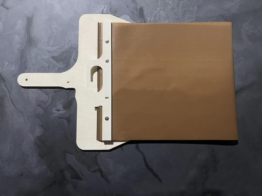 Pizza peel with fabric belt lying flat on a dark background