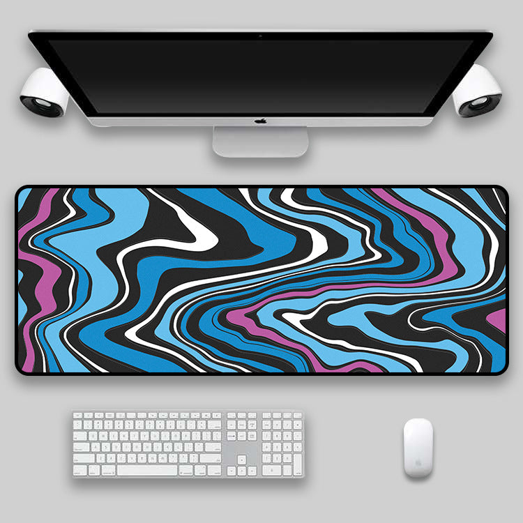 Blue and orange swirl desk mat on a desk with monitor, keyboard and mouse