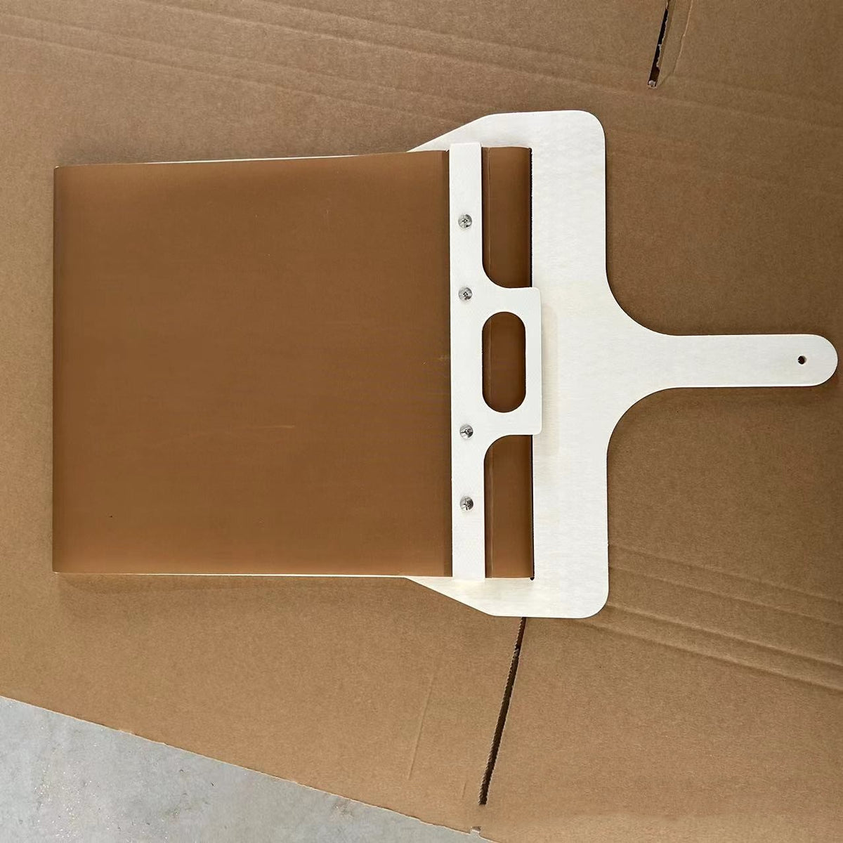 Top view of the sliding pizza peel showing the fabric belt, wooden bar and handle