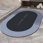 Slate blue oval bath mat with a black centre on a stone floor