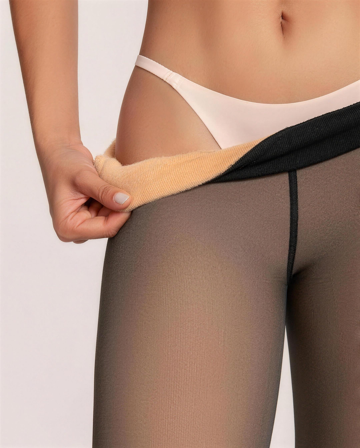 Black tights waistband turned out to show the fleece inner layer of the high-waist panel above the sheer-look leg