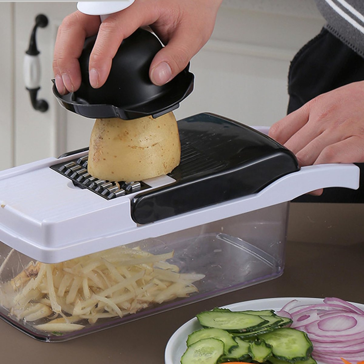 Hand slicing a potato into julienne strips with the vegetable chopper mandoline and hand guard