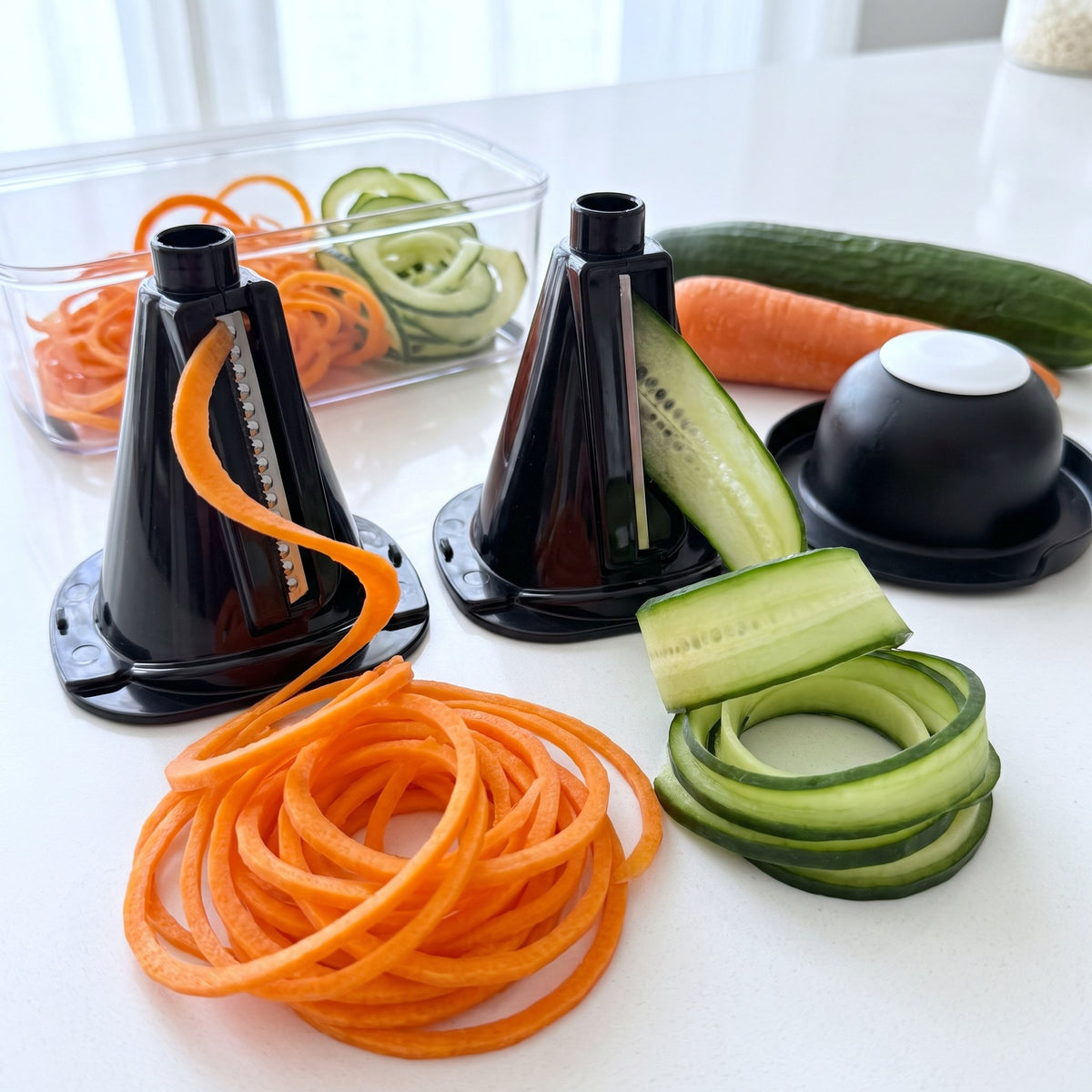 Spiral and ribbon blade cones making carrot and cucumber spirals, with the hand guard and clear container